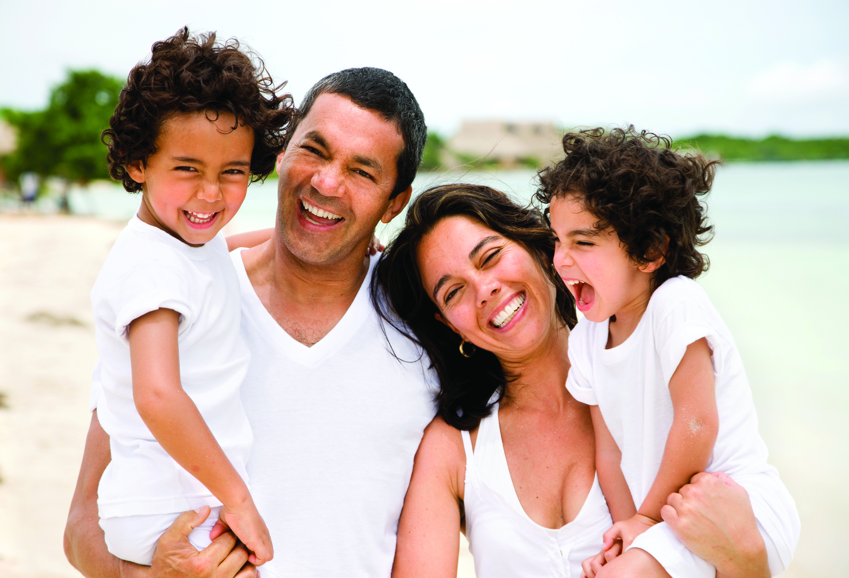 family smiling on beach shore, family dentistry Ocean Township, NJ